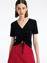 a lady in black pleated v-neck  knit top